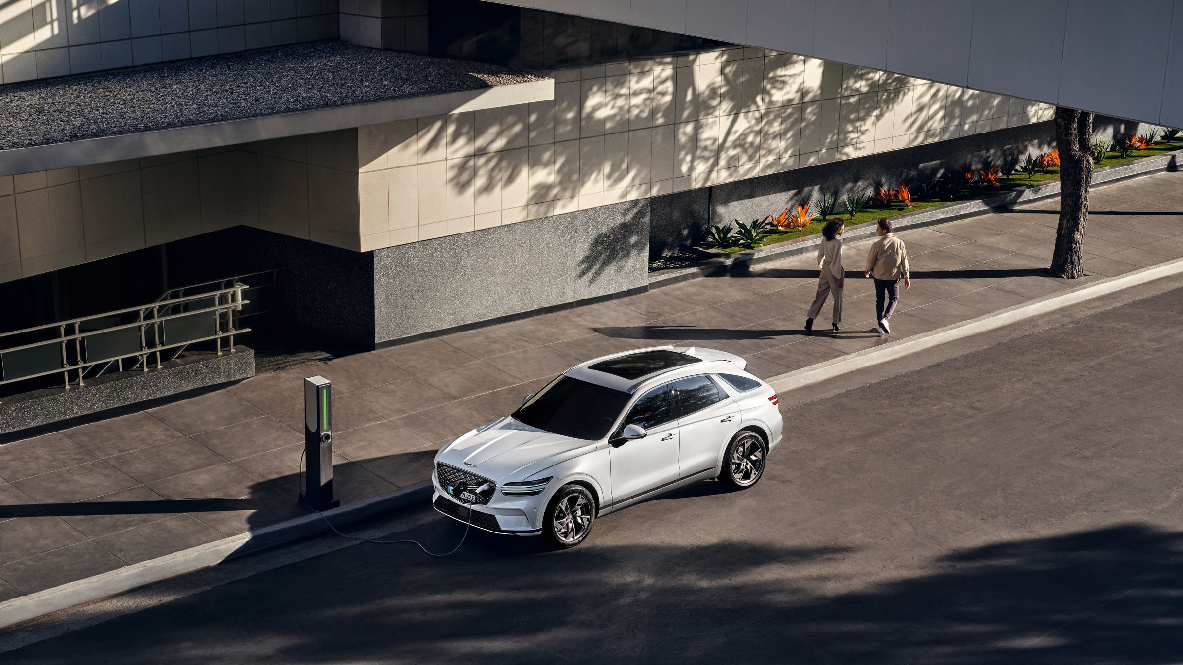 Genesis GV60 in Weiß steht an einer Ladesäule in der Stadt